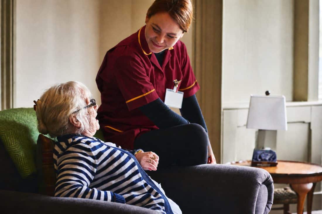 A support worker helping an older woman at home
