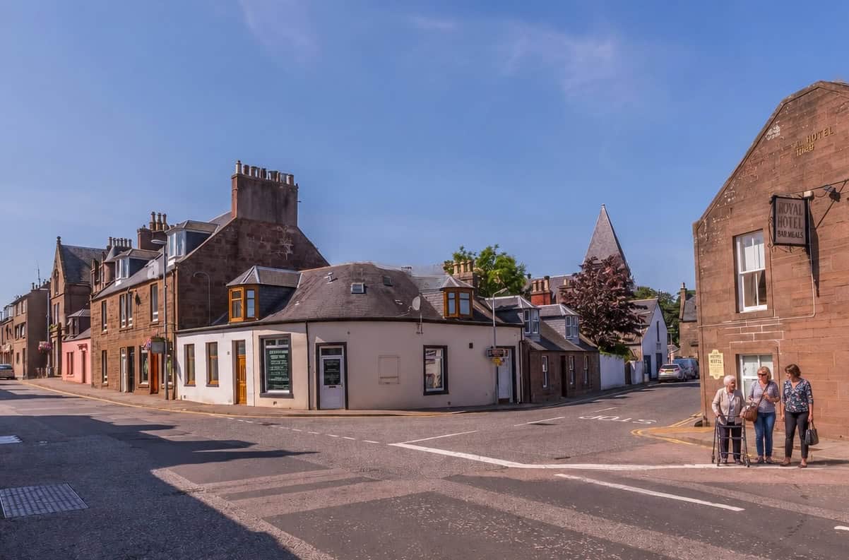 Scenic view of a historic town center in Angus & Mearns with old buildings and a clear blue sky.